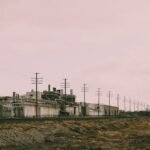 A landscape view of industrial power lines and a factory with multiple utility poles.