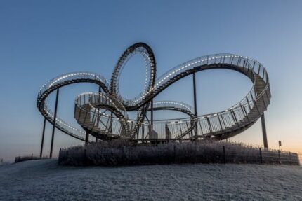 Explore the Tiger and Turtle sculpture at twilight, a modern architectural marvel in Duisburg, Germany.