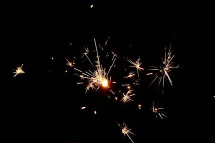 A vibrant display of sparklers glittering against a dark background.