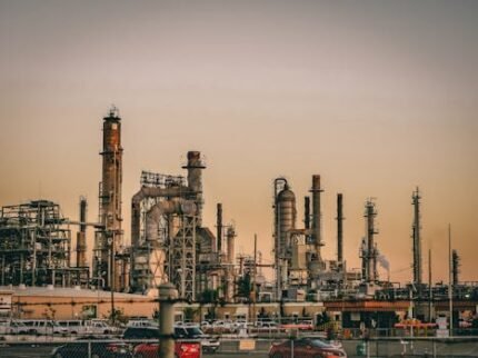 A large industrial power plant silhouetted against the warm hues of a sunset.
